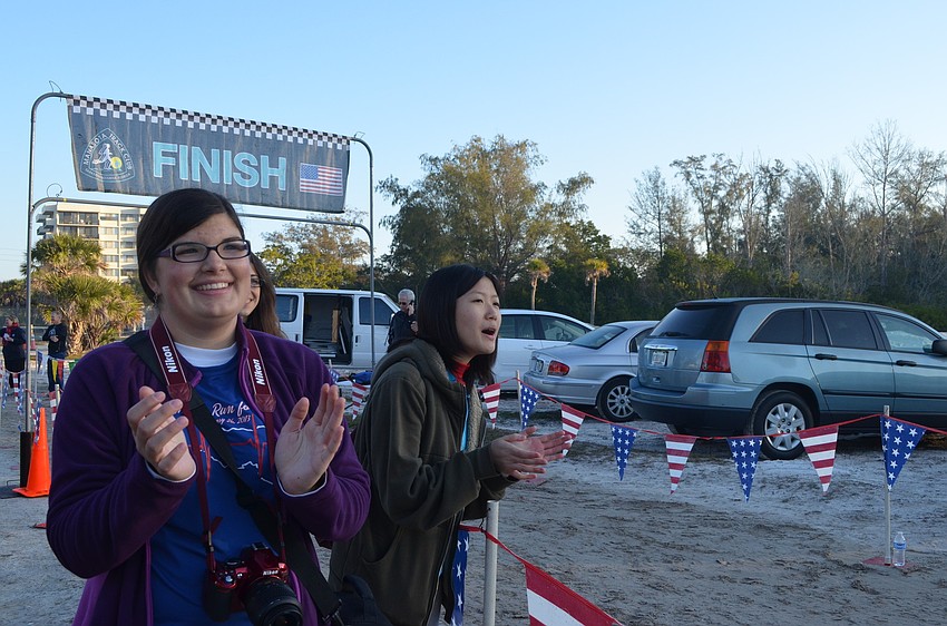 Fiorella Nicoloso and Christine Chern cheer runners on at the finish line.