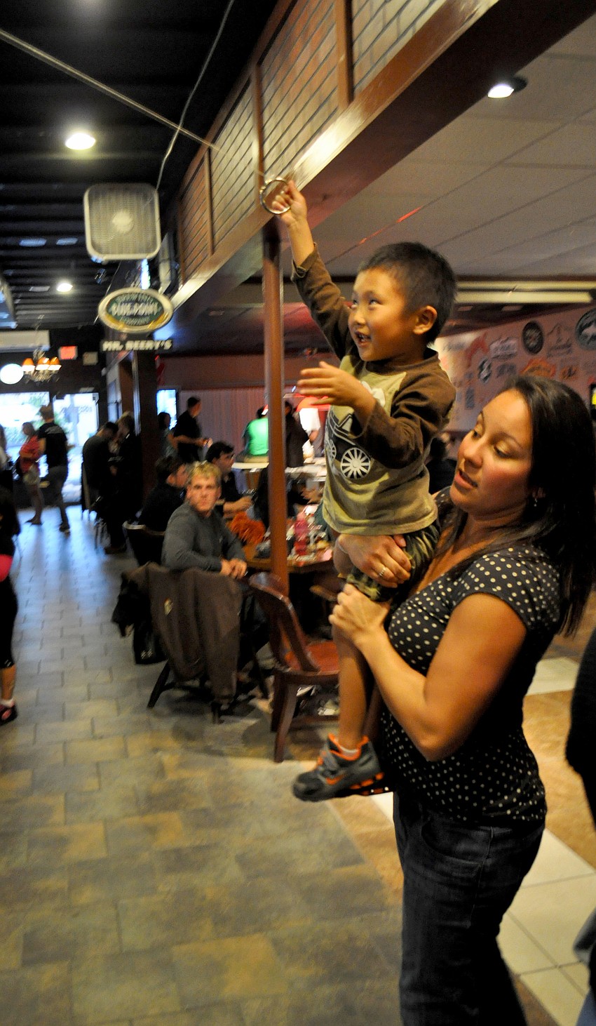 Anna Bello watches as Ethan Loefler plays the ring-and-hook game.