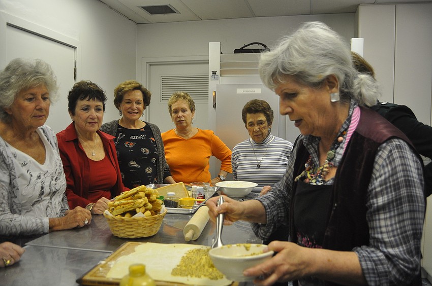 Sylvia Pastor applies Dijon mustard to the puff pastry to make mustard batons.