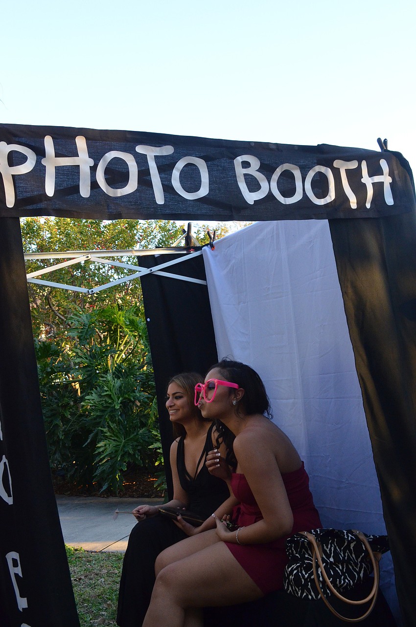 Esin Gurani and Randi Etienne take photos in the photo booth.