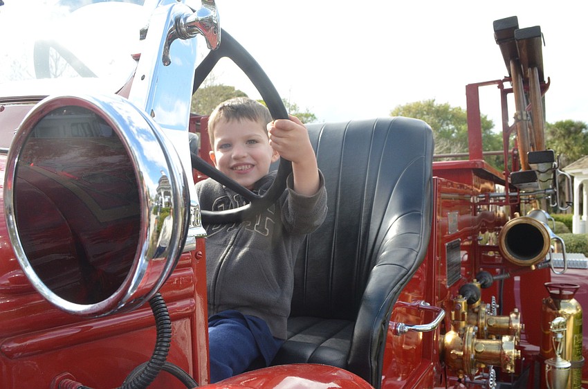 Three-year-old Ethan Gooch takes a seat behind a 1945 Mack Fire Truck.