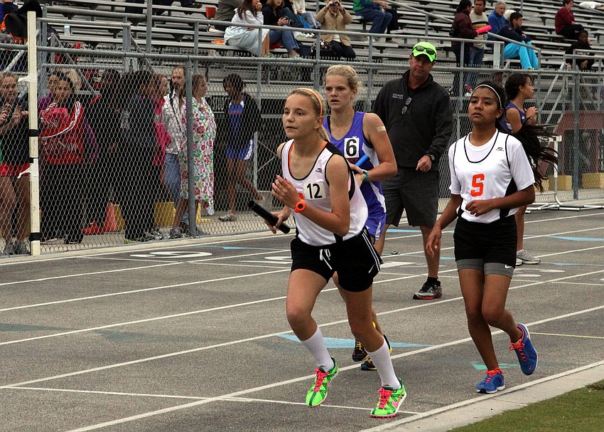 Morgan Holmes, freshman, runs with the baton after it was handed off to her by her teammate Tanya Munoz, freshman.