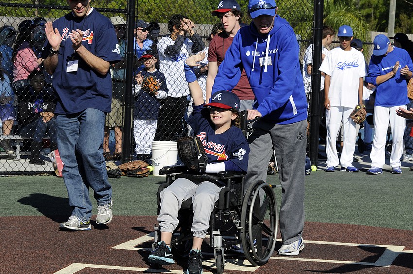 First-year player Savannah Miller waves to the crowd after scoring her first run of the season.