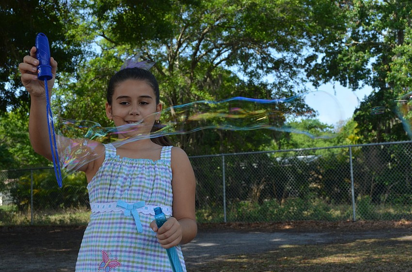 Ali Kaiser-Andradi plays with a magic bubble wand.
