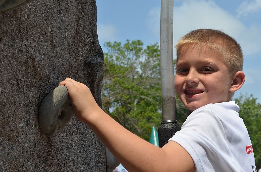 Blake Diamond climbs the rock wall.