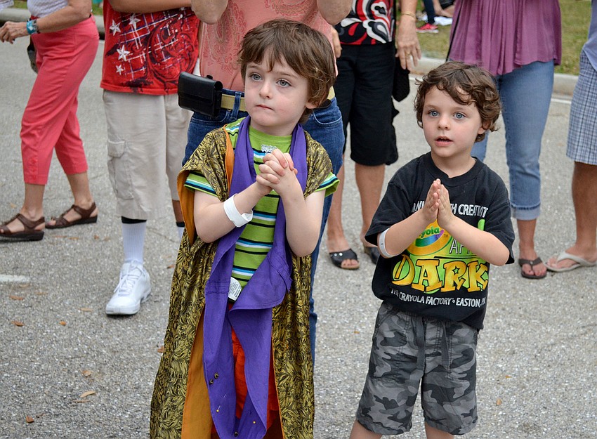 Kennedy Cole and his brother, Avery, watch as a band plays.