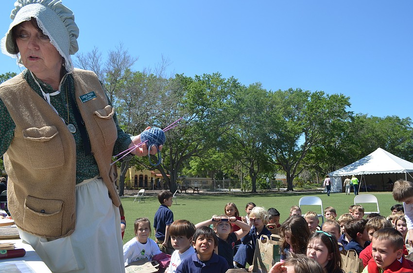 Spanish Point Volunteer Linda Trigg tells children about household chores of the past.