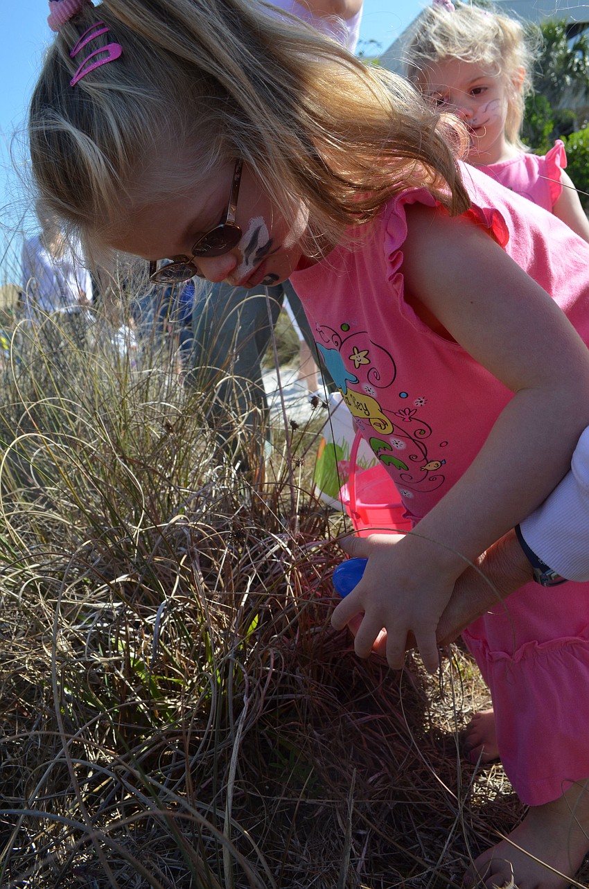 Amber Rossi finds an Easter egg in the grass.