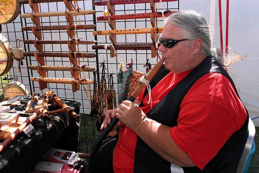 Mark Barfoot plays one of his flutes at his tent Wolf Creek Art Friday, Jan. 25, at the Native American Indian Festival at the Sarasota Fairgrounds.