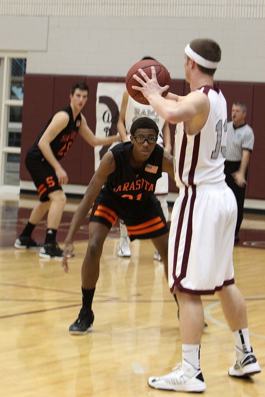 Riverviewâ€™s James Robustelli, No. 13, looks to pass the ball while Sarasotaâ€™s Shaquese Johnson, No. 31, attempts to guard Robustelli.