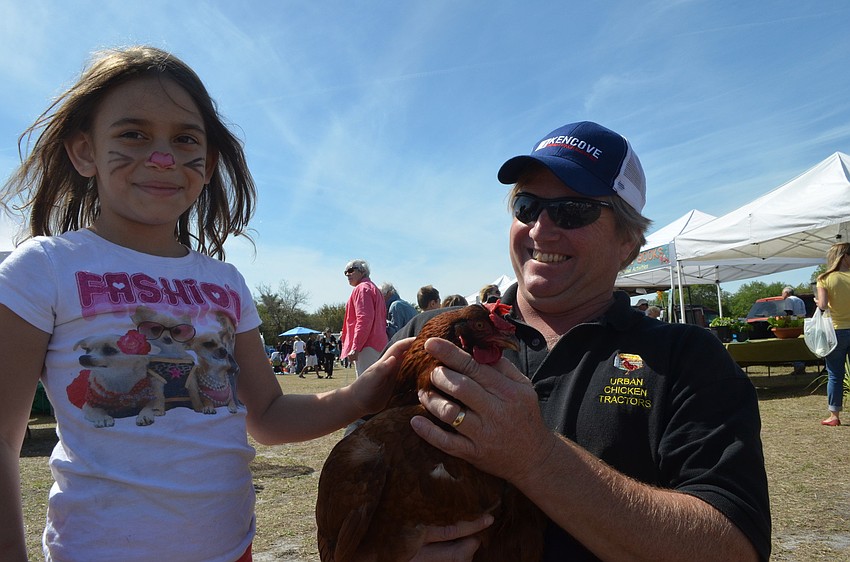 Hannah Friedman pets a hen Urban Chicken Tractors. Ira Klineschmidt makes wheelbarrow like shelters for chickens for ease of movement and urban chicken health.