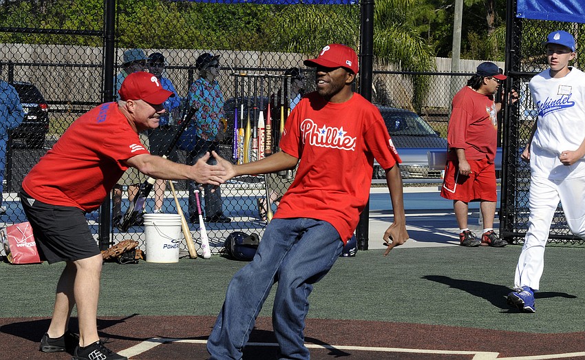 Everette Byrd is congratulated by one of his coaches after scoring the Phillies first run of the game.