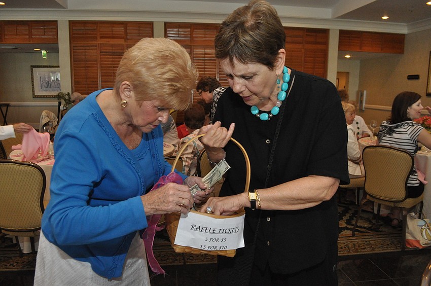 Gerry Sullivan buys a raffle ticket from Mary Saunders.