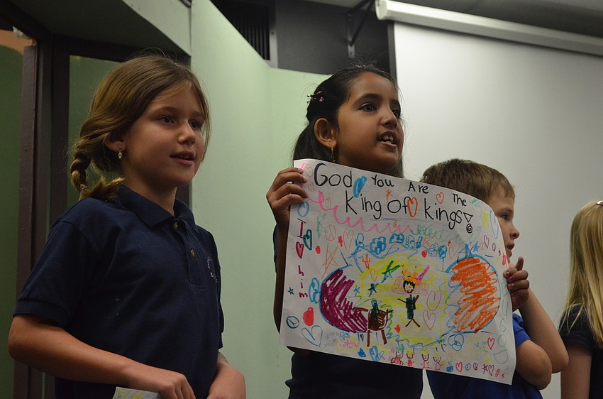 Chloe Johnson and Nishalle Uthuppan show of the pictures they drew and tell their grandparents.