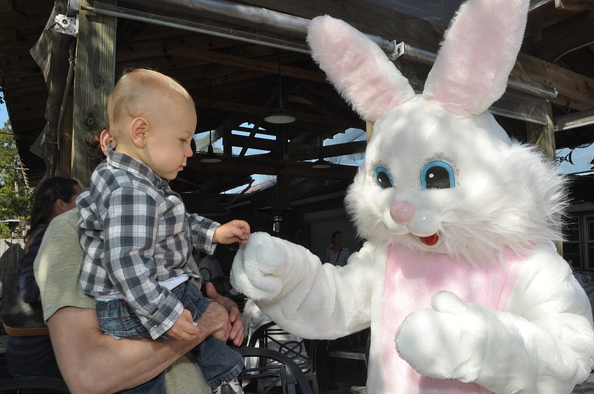 Dash Garden, 1, taps fists with the Easter Bunny.