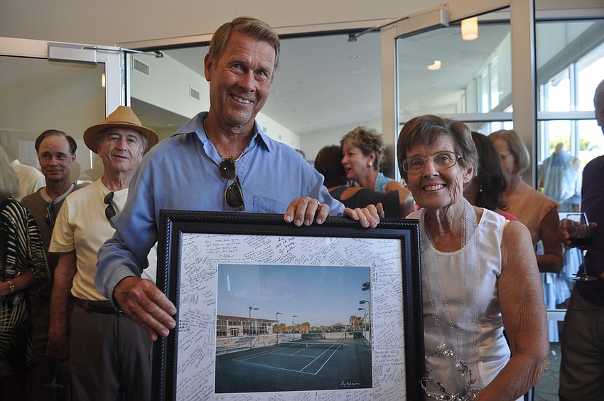 John Woods and Sue Brown with a poster of the tennis gardens, which members signed.