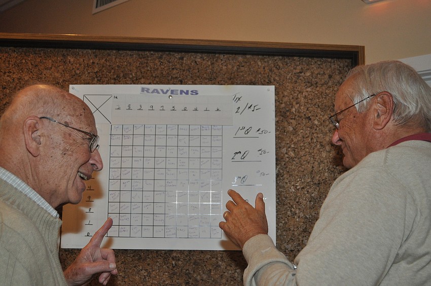 Bill Forcht explains the point-spread pool to Mort Silverberg at the Beachplace Super Bowl party.