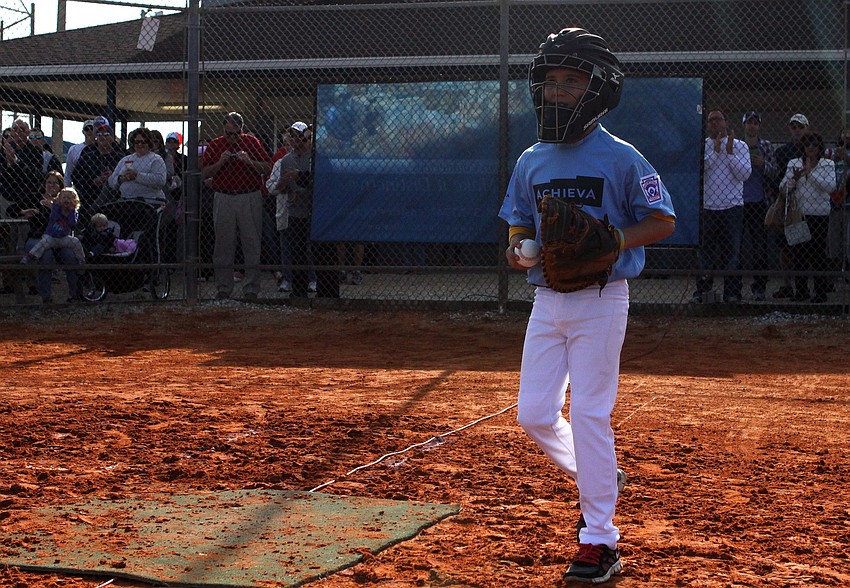 Eli Drews, 9, runs back after catching the first pitch thrown by his dad and coach, Matt Drews.