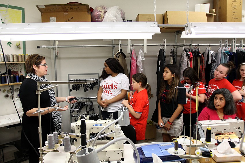Susan Brothers, operations manager, shows the girls around the alterations room during their tour Wednesday, Feb. 20, of Saks Fifth Avenue.