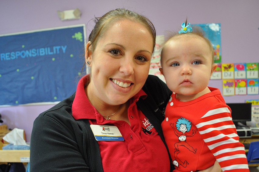 Preschool Assistant Director Christina Robertson dresses her 5-month-old daughter, Harper, for the celebration.
