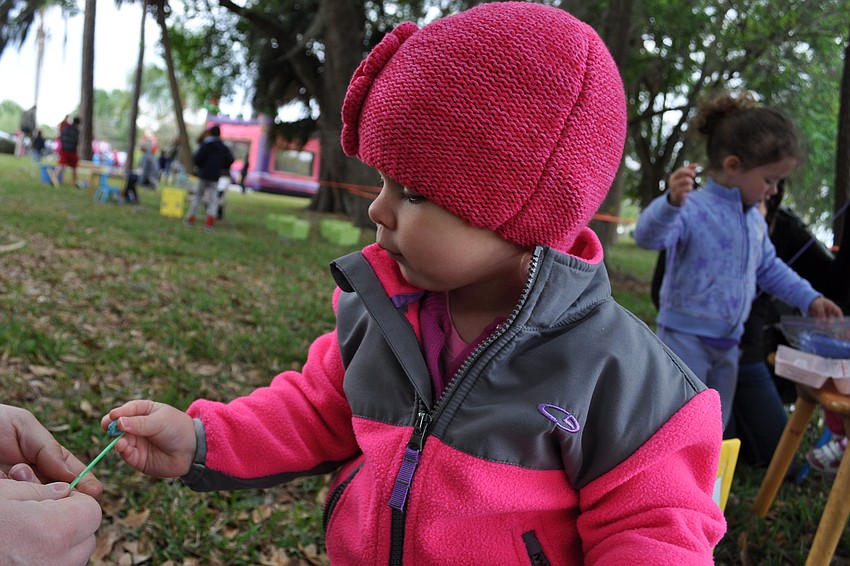 Leah Glynn, 21 months, hooked fruit loops, with the help of her dad, David, to create a cereal necklace.