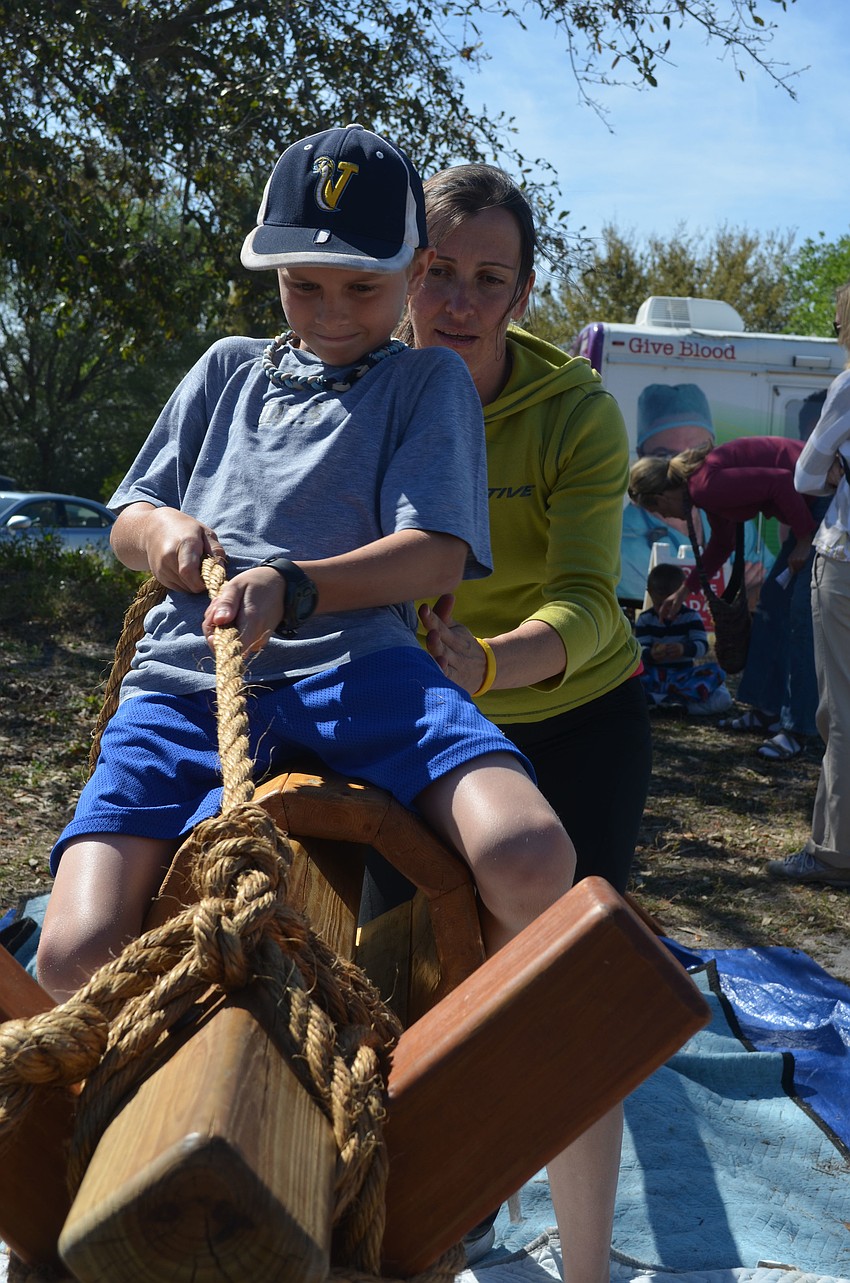 Garret Parisi, 10, takes a ride on a wooden battle horse with the assistance of Krisztina Ihaszy in Pinocchioâ€™s Land. Ihaszy makes the games herself.