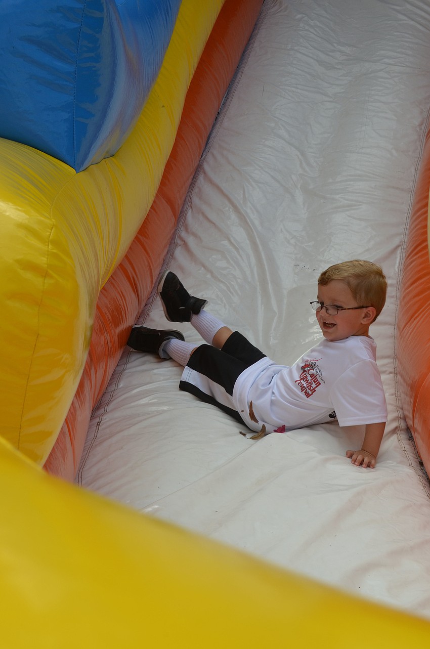 Walker Beach slides down a big blow up slide.