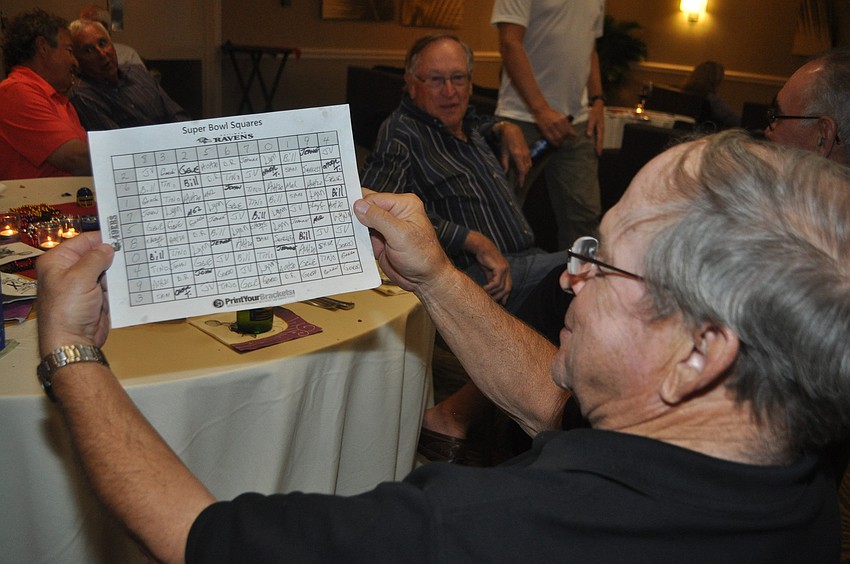 Jim Viera consults the Longboat Key Club Super Bowl point spread sheet.