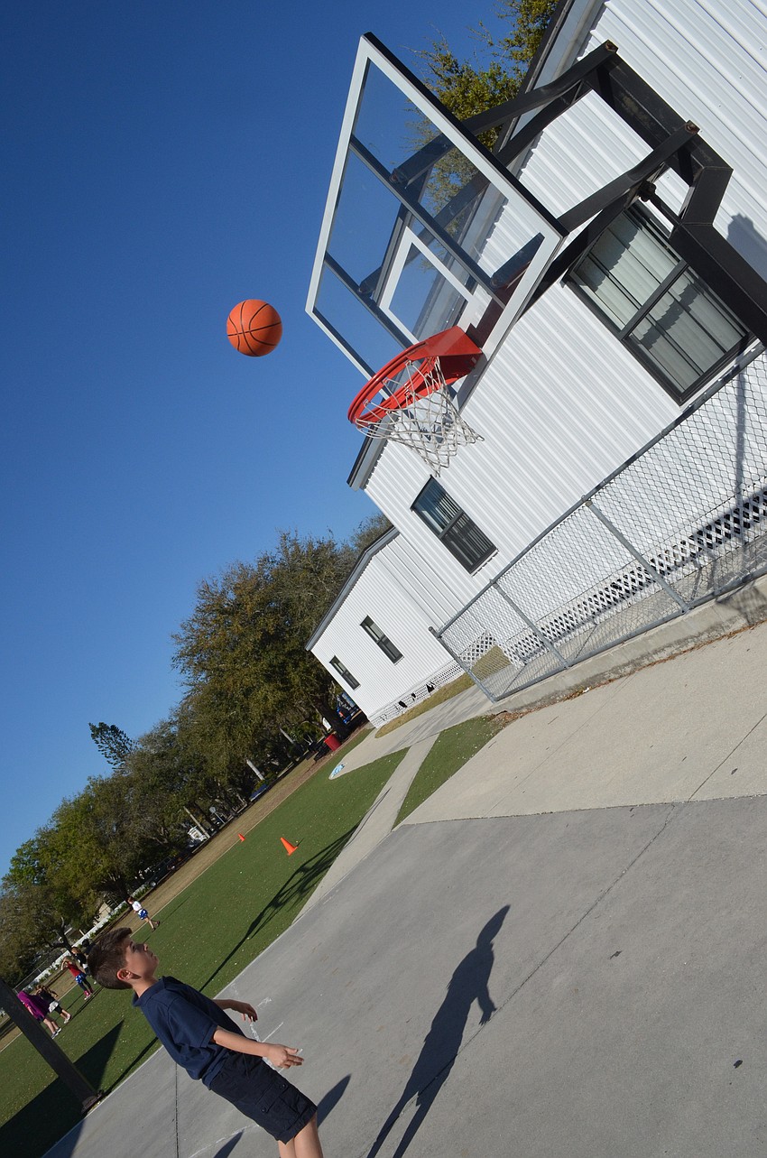 Fourth grader Domenic Maglio shoots hoops during gym class.