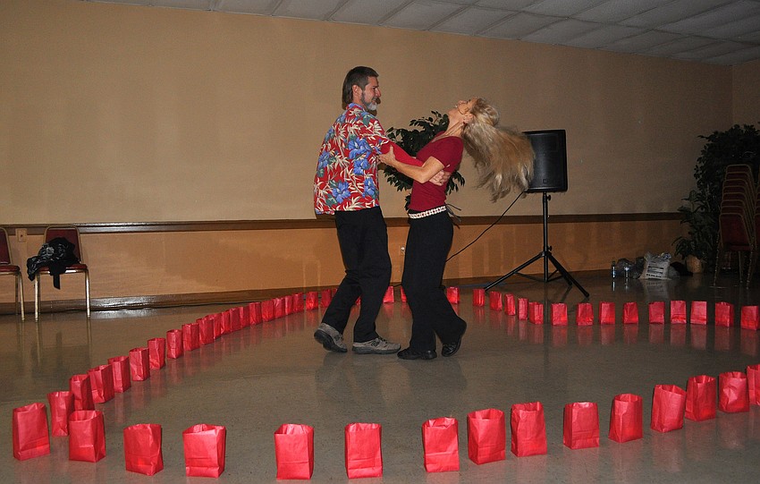 Jeff Hanna and Barbara Gail dance together in the heart created with red paper bags.