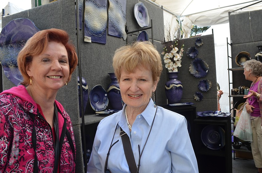 Kathleen Duyvejonck and Brenda Bricker look at various potteries at the festival.