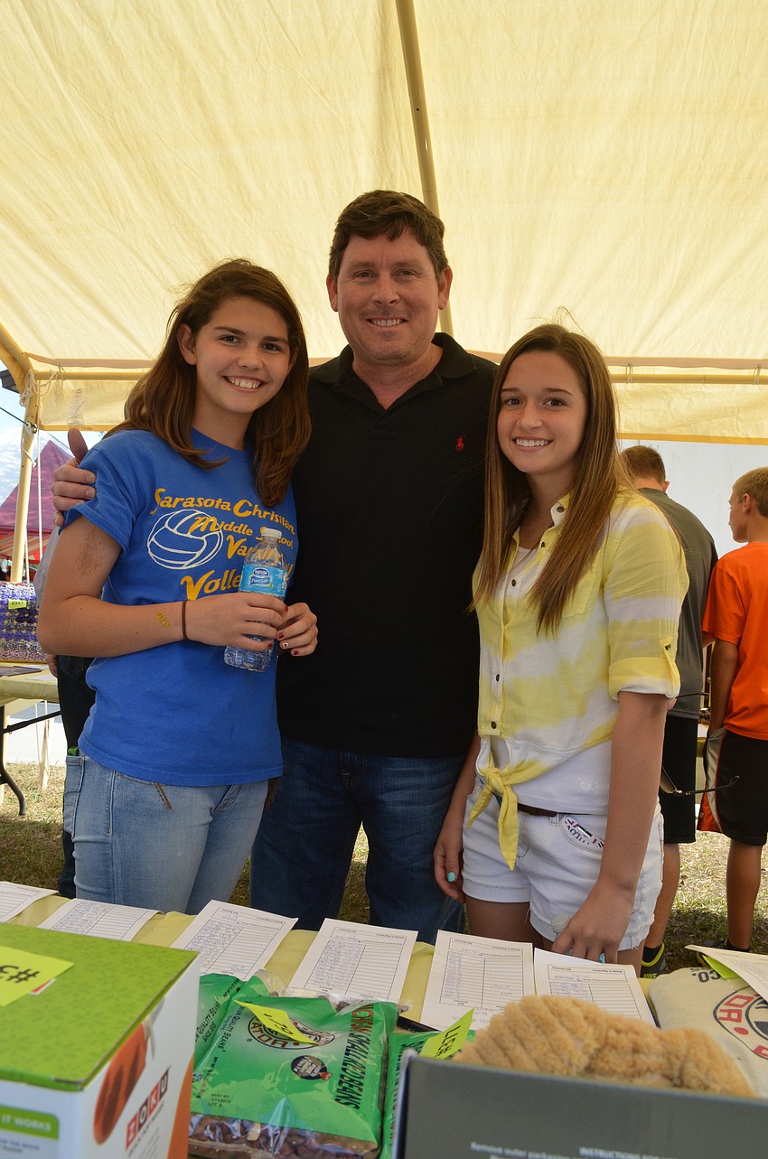 Lexi Dingle selects silent auction items with her father Sean and Alyssa Schrag.