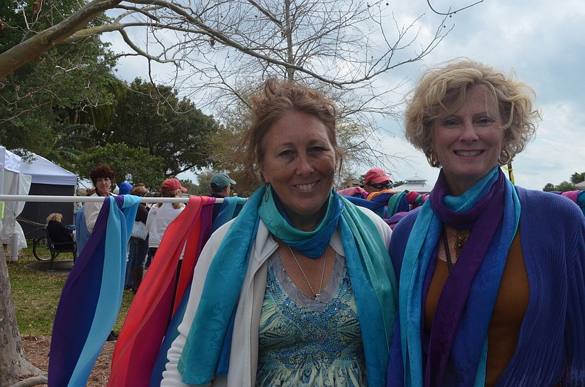 Artisan Anna Champaign hand paints silk scarves. She stands with customer Jane Hamlin.