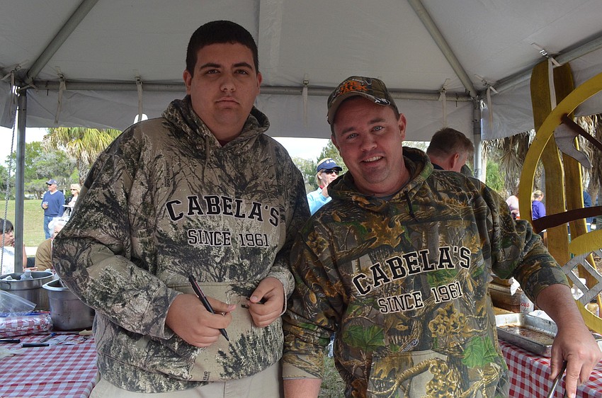 Cody Niver passes out ribs with his father, Rick.