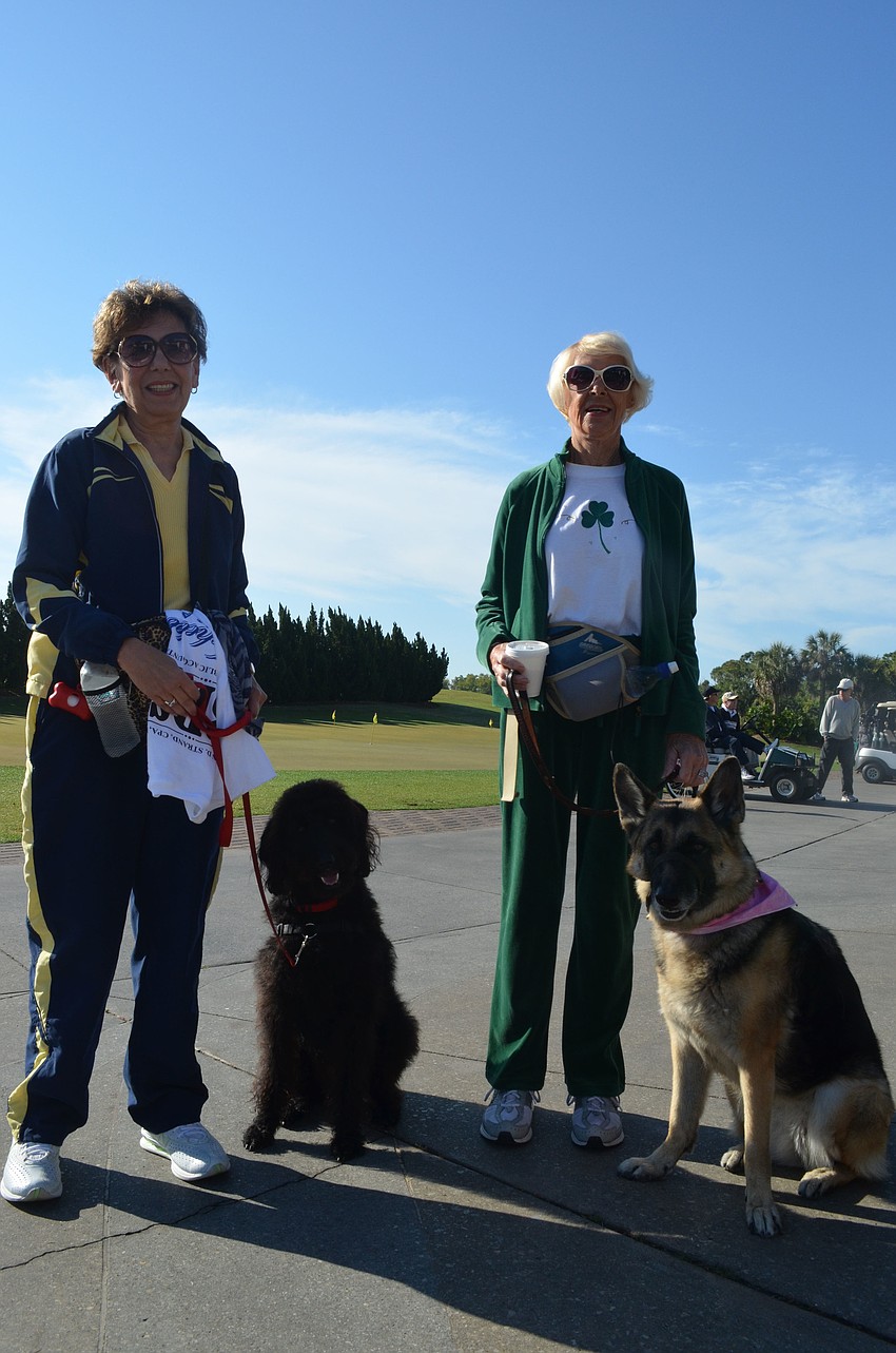 Carol Siegel walks with her labradoodle, Roxy and Babe Hart walks with her German shepherd, Diamond.