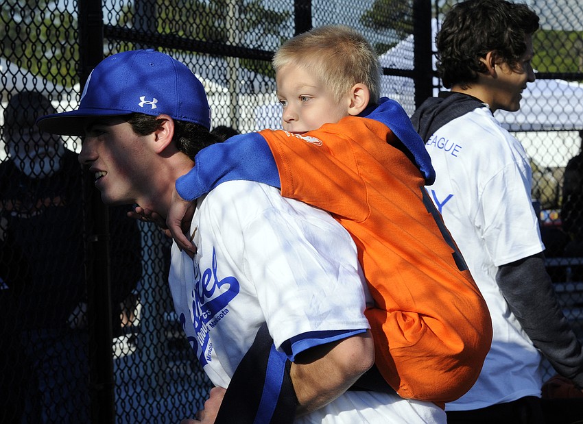 Six-year-old Leo Powell quickly bonded with his buddy and the rest of the IMG Academy U15 baseball team.