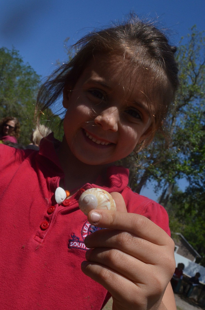 Kindergartner Rowan Van Dender shows off a shell from the Mote Marine Aquarium zone.