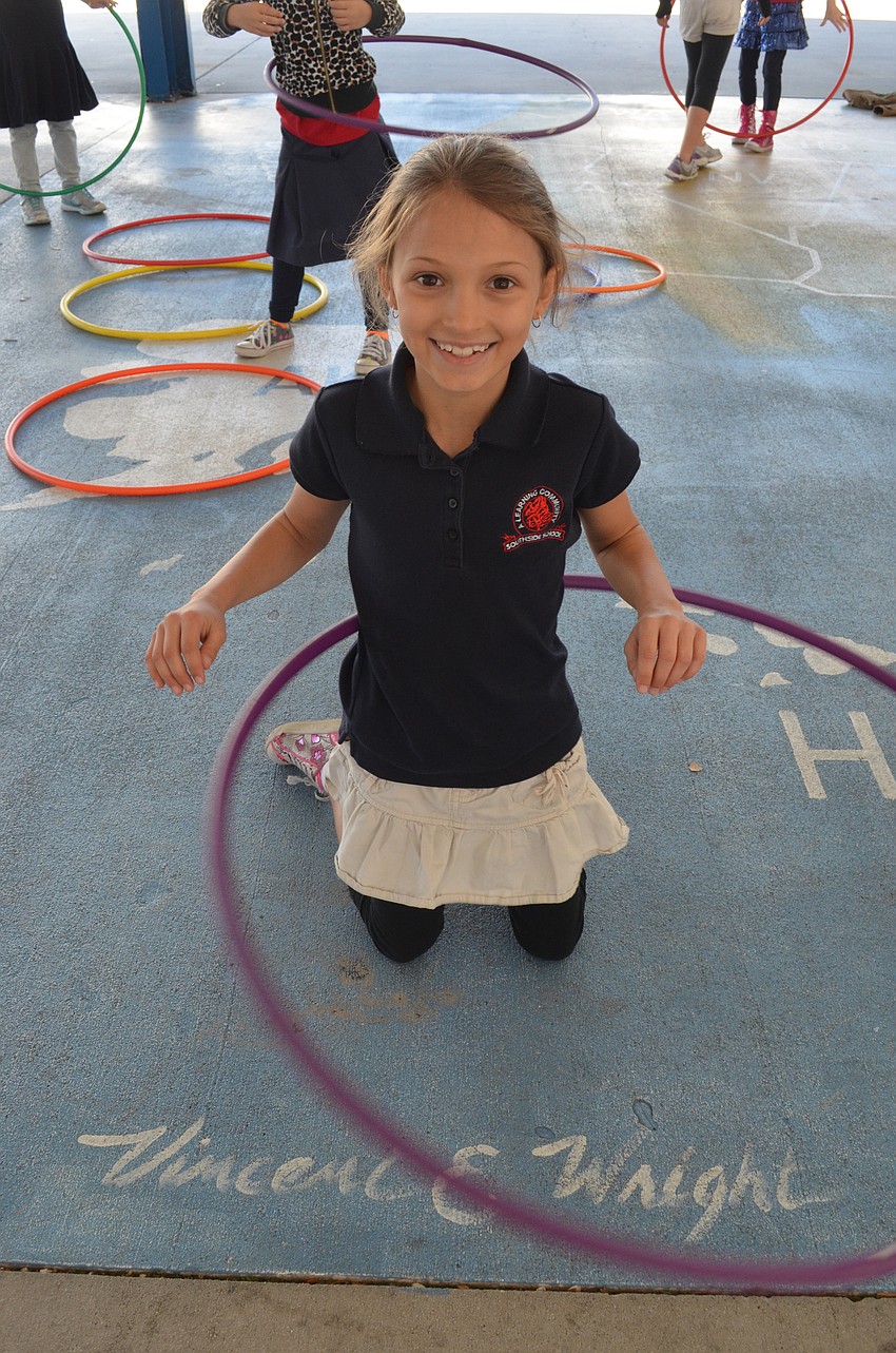 Ella Menke, 7, demonstrates how to hula hoop kneeling.