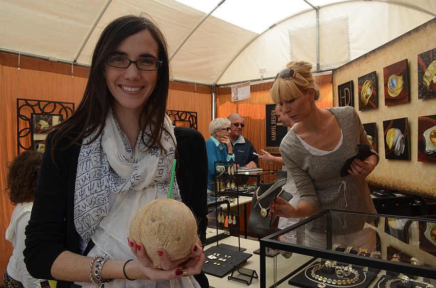 Sydney Spann visits the art festival and enjoys a coconut beverage.
