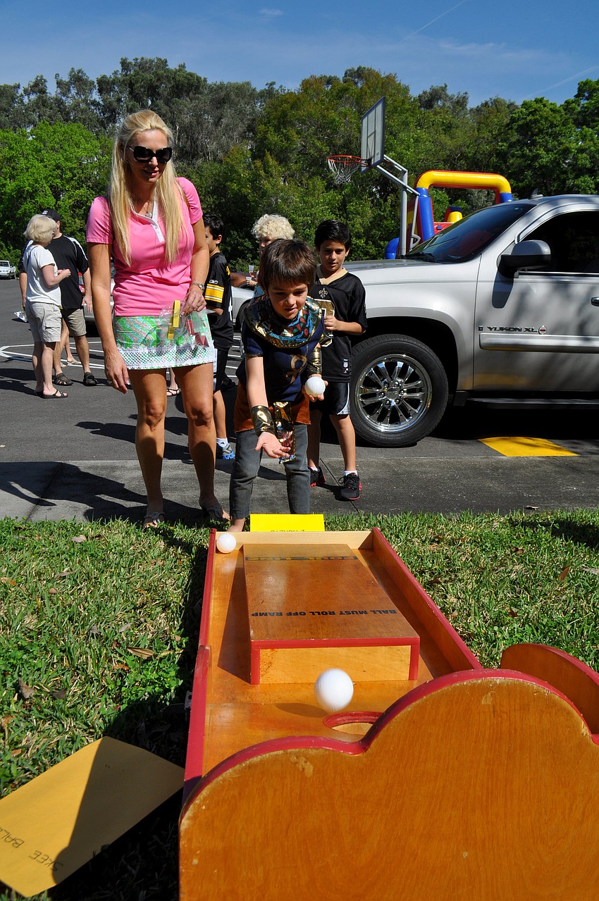 Melissa Fox watches as Rocco Rell tries his hand at a carnival game.