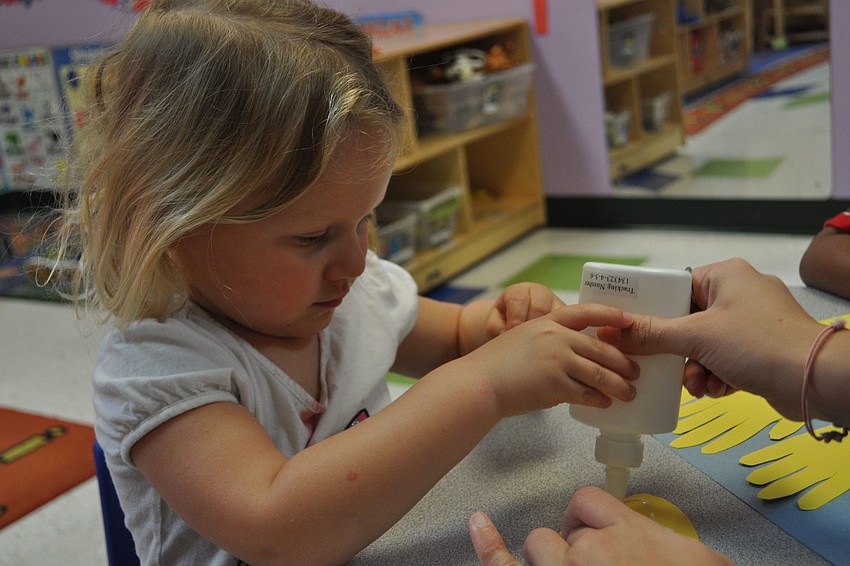 Madison Rupert glues hands onto her hat creation.