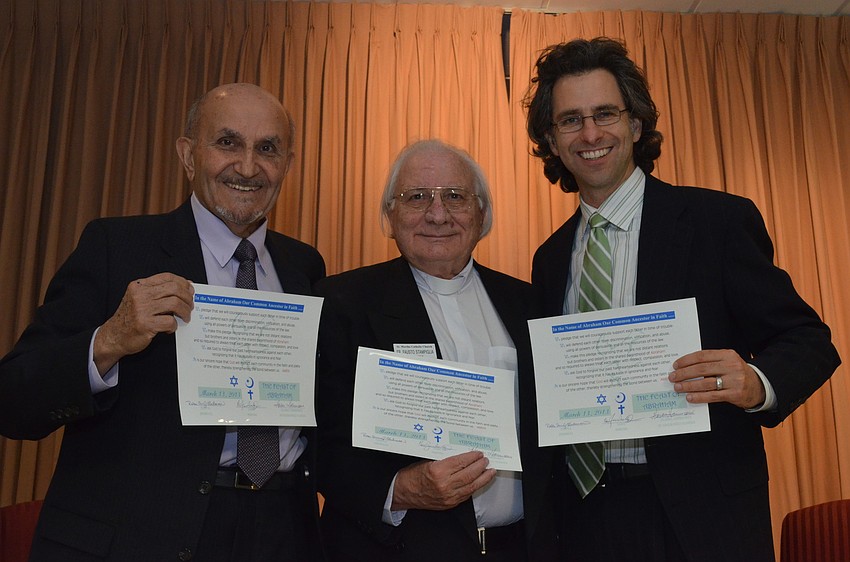 Hassan Hammami of the Islamic Community of Southwest Florida, Father Fausto Stampiglia of St. Marthaâ€™s Catholic Church and Rabbi Brenner Glickman of Temple Emanu â€“ El sign an all faiths certificate.
