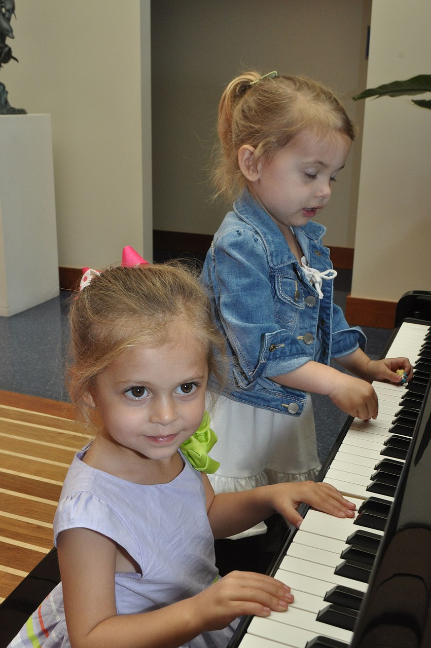 Riley Edbrooke, 3, and Samantha Chessler, 3, tickle the ivories.