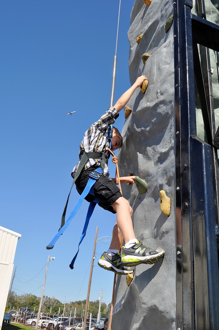 Aiden Nisberg climbs the rock wall.