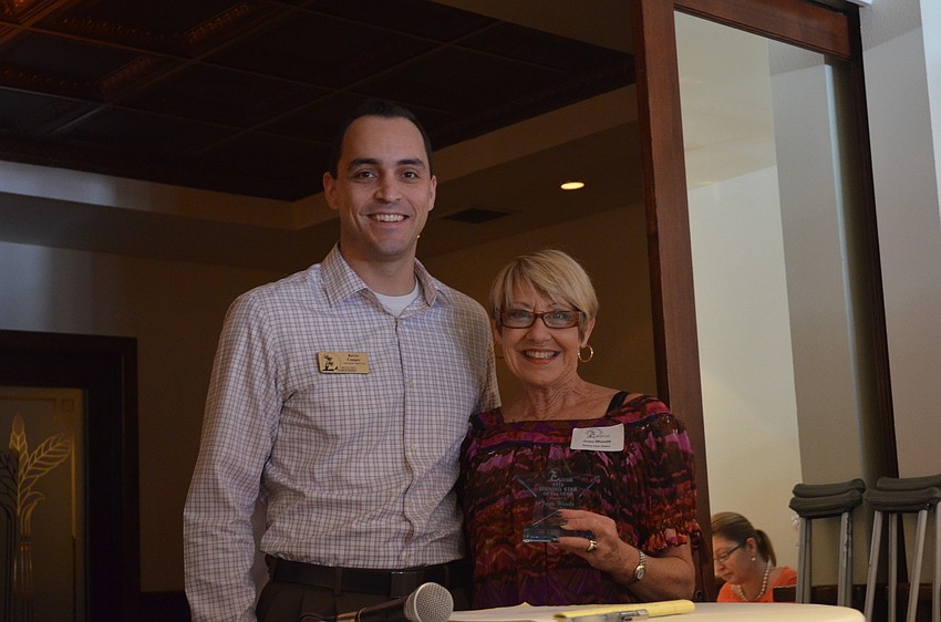 Kevin Cooper hands Joan Woods of Sassy Hair Salon the 2012 Shining Star Award.