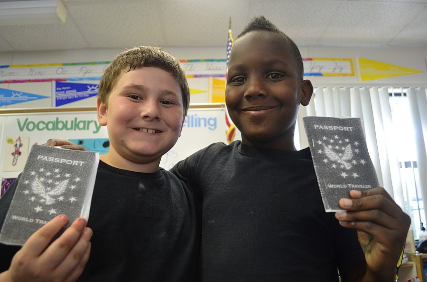 Hunter Coomer, 9, and Zepharin Williams, 9, show off their passports as they travel from classroom to classroom.