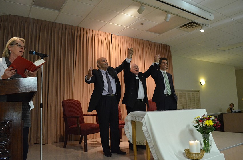 Stampiglia of St. Marthaâ€™s Catholic Church and Rabbi Brenner Glickman of Temple Emanu â€“ El join hands and sing Let There Be Peace on Earth with Sheryl Wiegers and faith members.
