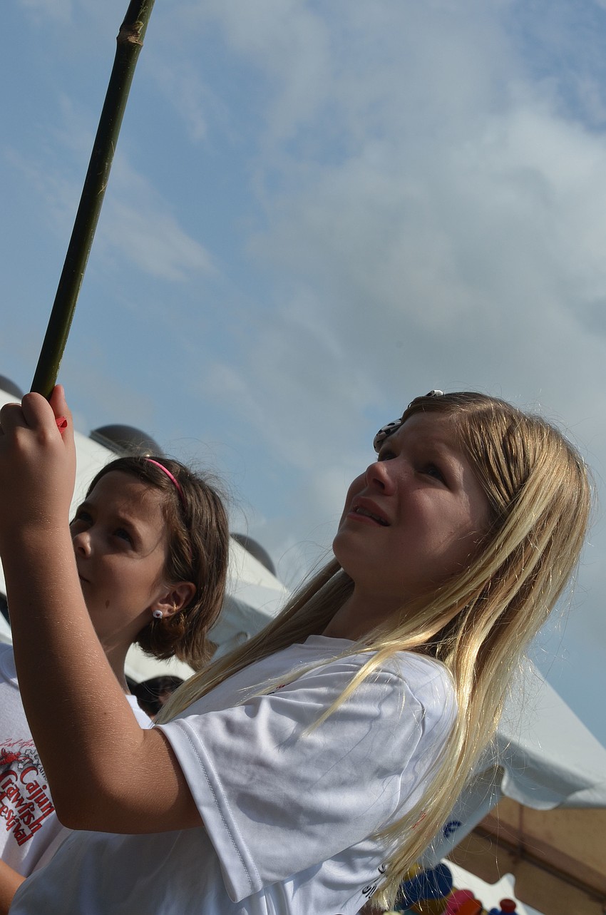 Clara Pokorstei fishes for a prize in a carnival game.