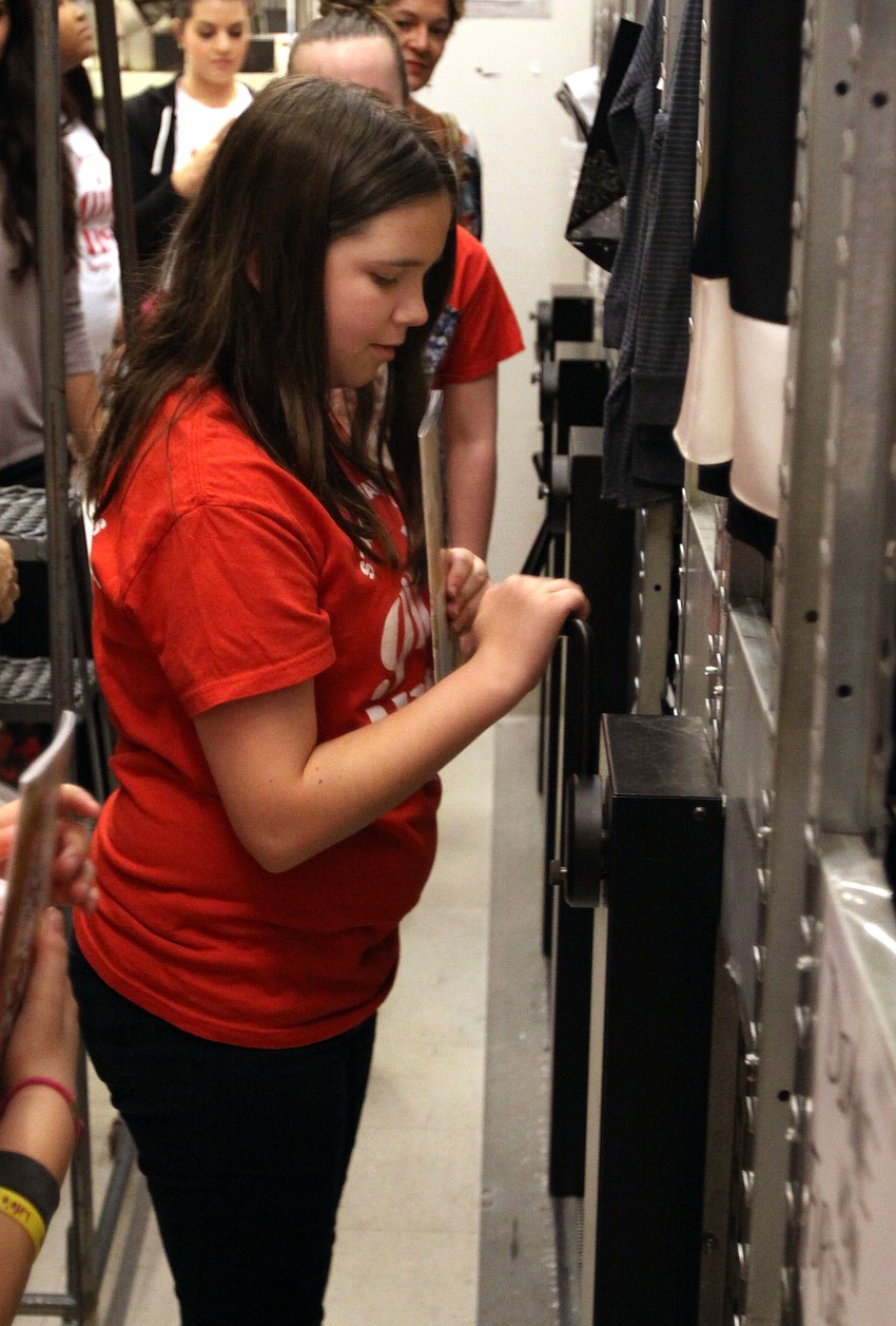 Mikayla Klauber has a chance to move the moveable shelving units in one of the back rooms of the store.