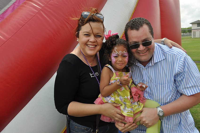 Patricia, Damaris and Eugenio Quirones outside a bounce house